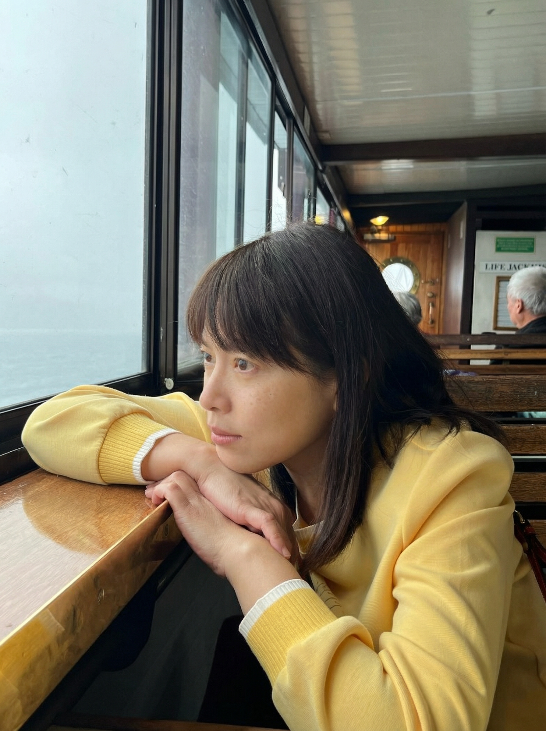 坐在渡輪窗邊凝望海天的女性